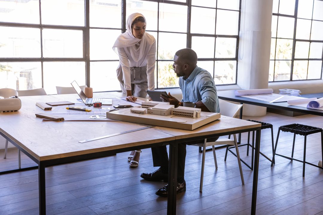 Diverse Architects Collaborating Over Scale Model in Modern Studio