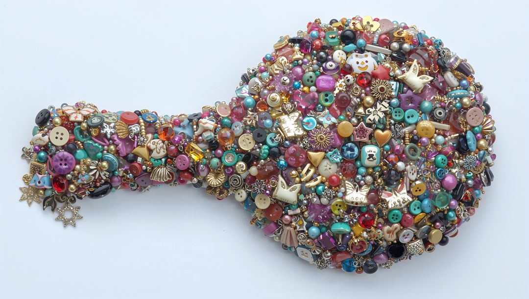 Paddle-shaped craft mosaic featuring vibrant buttons, beads, pearls and rhinestone charms