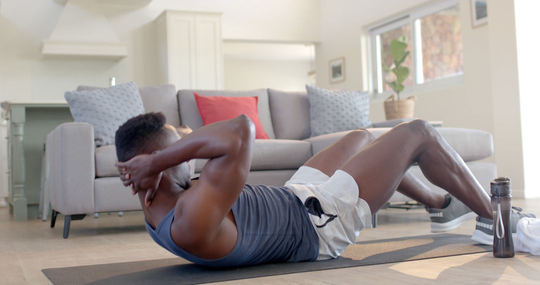 Man Exercising with Sit-Ups in Modern Living Room - Free Images, Stock Photos and Pictures on Pikwizard.com