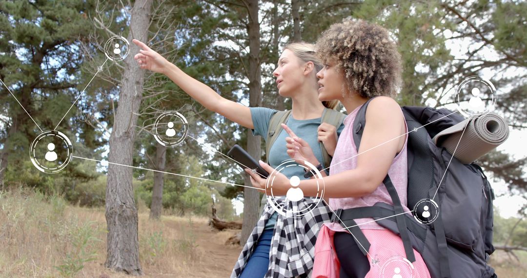 Two Women Hiking Pointing and Navigating with Smartphone and Digital Network Overlay