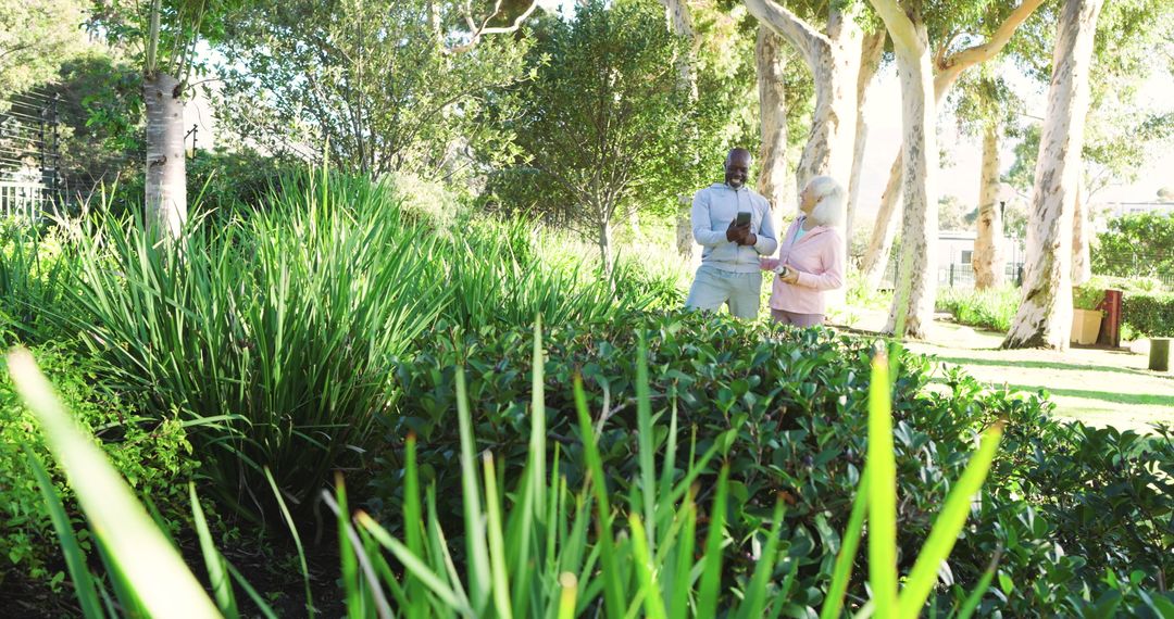 Colleagues Reviewing Digital Tablet in Sunlit Garden