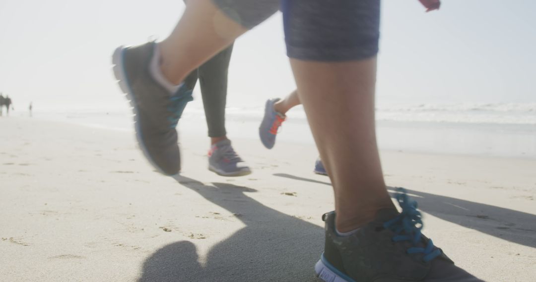 Close-Up of People Jogging on Beach During Sunny Day - Free Images, Stock Photos and Pictures on Pikwizard.com