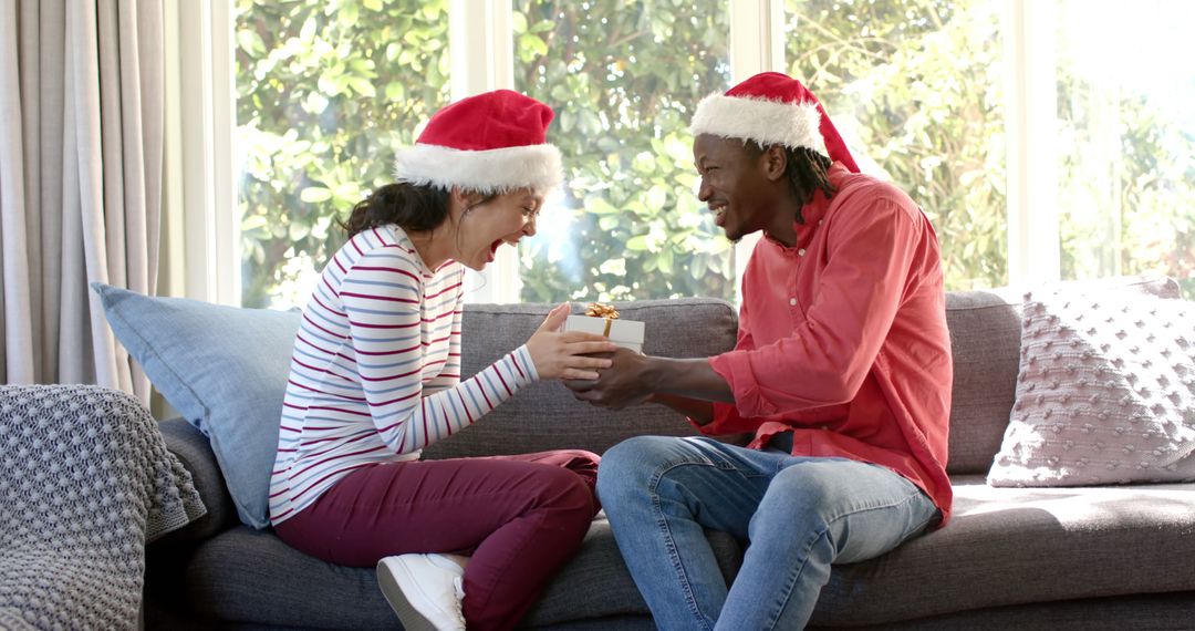 Joyful Couple Exchanging Christmas Gifts on Sofa - Free Images, Stock Photos and Pictures on Pikwizard.com