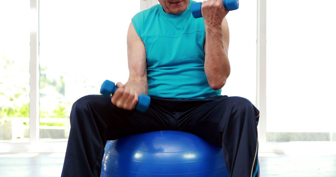 Senior man sitting on exercise ball at home - Free Images, Stock Photos and Pictures on Pikwizard.com