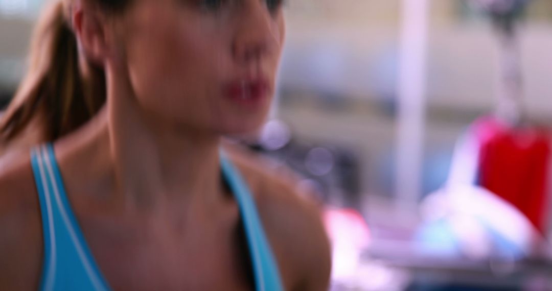 Focused Woman Training at Gym Blurred Background Emphasis - Free Images, Stock Photos and Pictures on Pikwizard.com