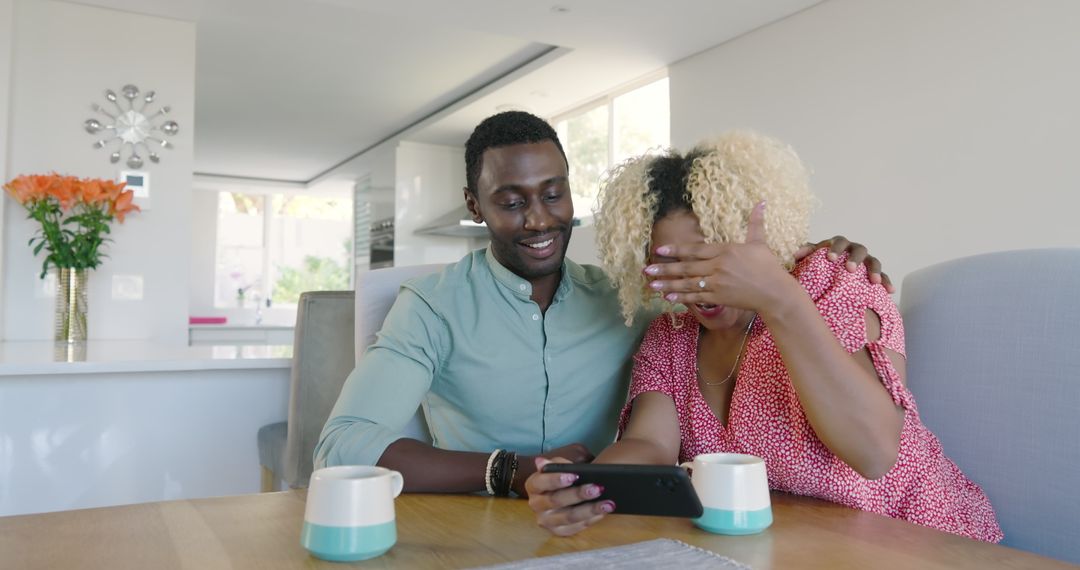 Couple Laughing Together Watching Smartphone at Home