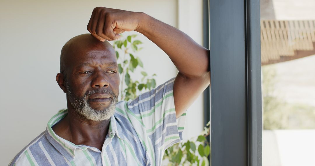 Pensive Mature Man Deep in Thought Near Window