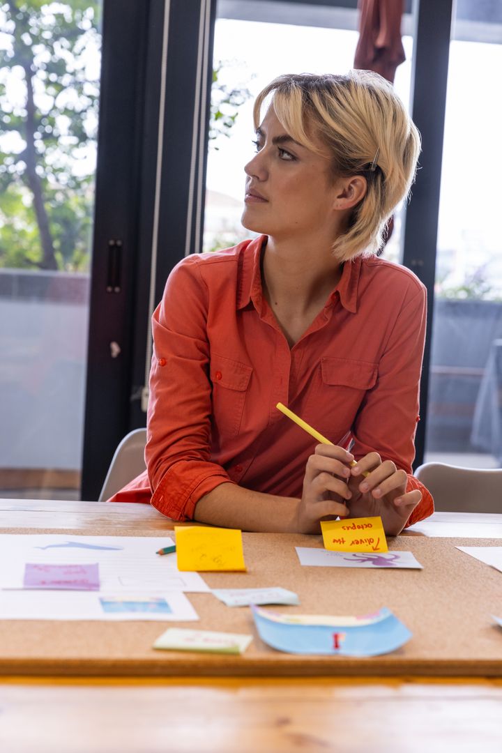 Young Woman Brainstorming with Sticky Notes at Design Workshop
