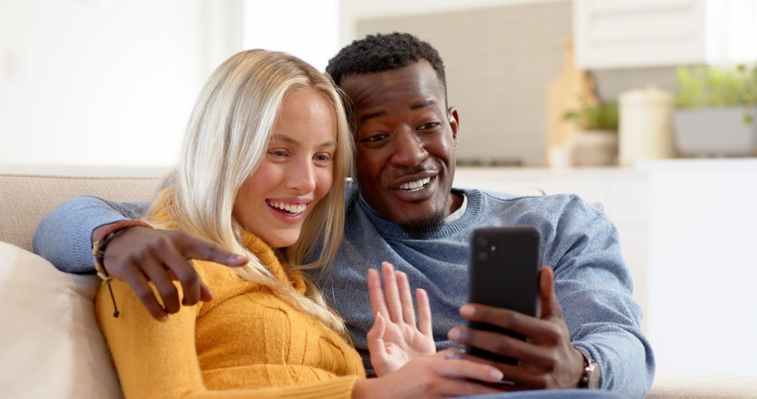 Diverse Couple Video Calling on Sofa Smiling