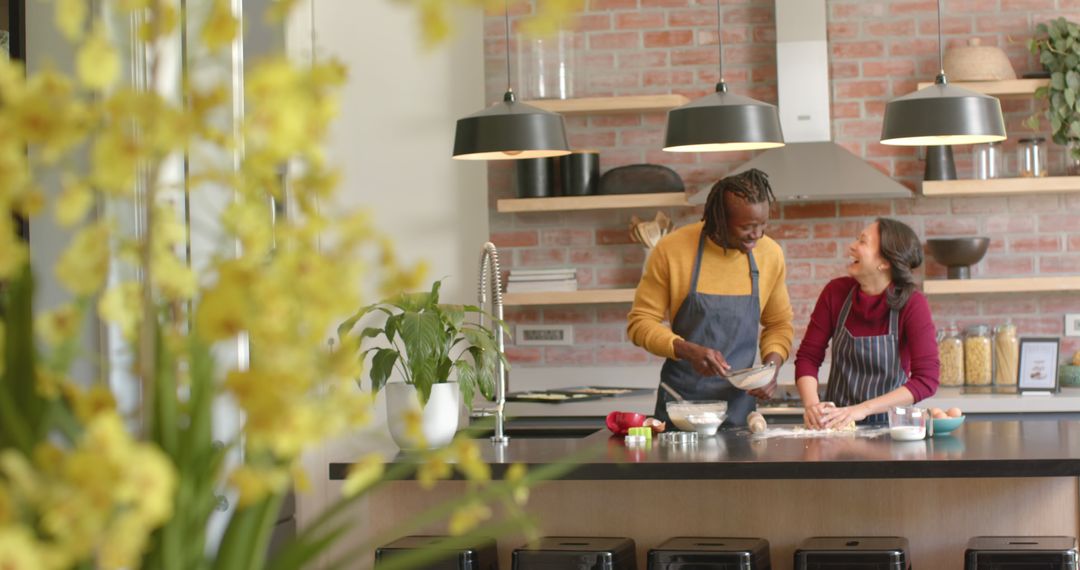 Couple Cooking Together in Modern Kitchen with Plants and Exposed Brick - Free Images, Stock Photos and Pictures on Pikwizard.com