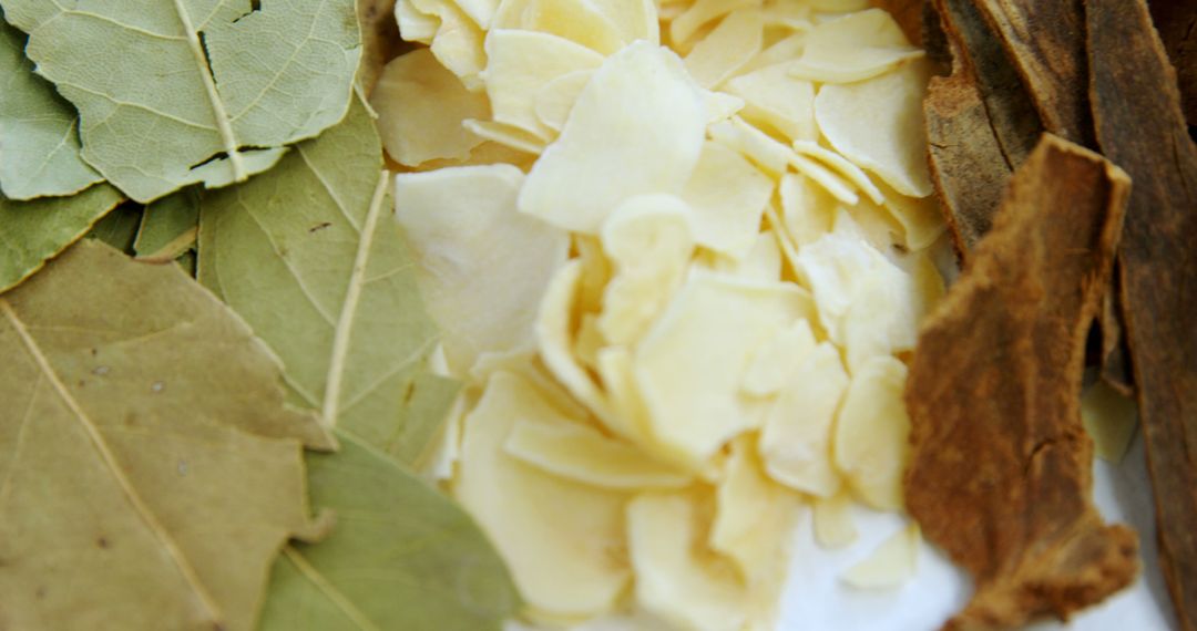 Close-up of Dried Bay Leaves, Garlic Flakes, and Cinnamon Sticks for Culinary Uses - Free Images, Stock Photos and Pictures on Pikwizard.com