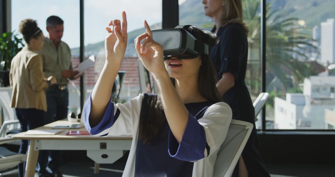 Woman Using VR Headset in Modern Office with Colleagues - Free Images, Stock Photos and Pictures on Pikwizard.com