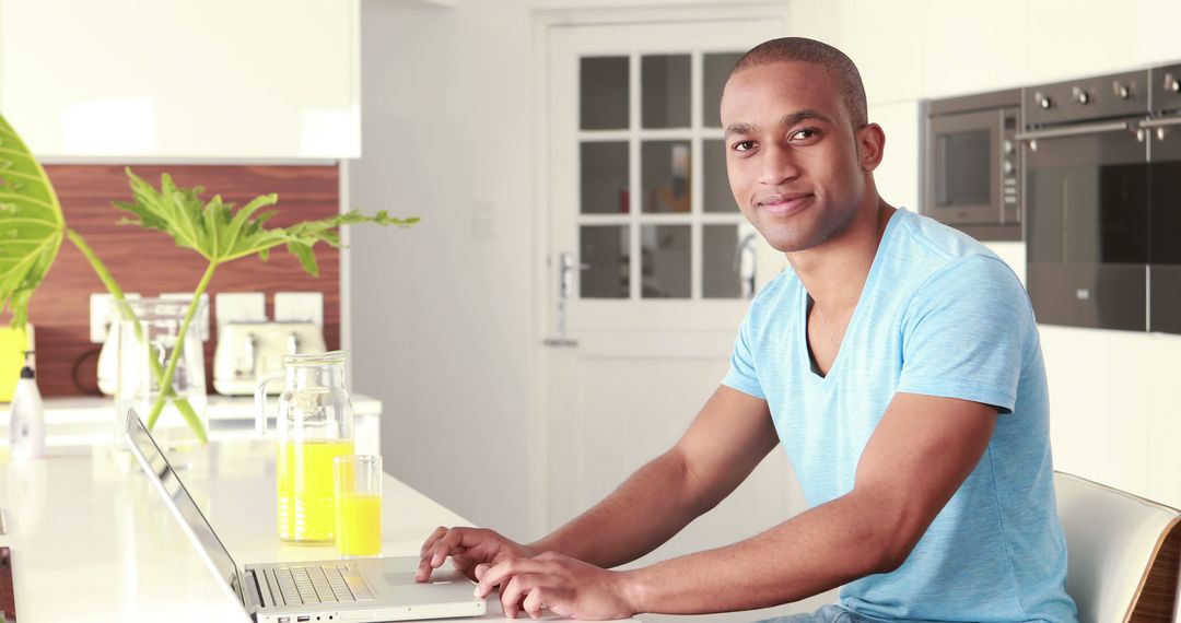 African American man working on laptop at kitchen counter - Free Images, Stock Photos and Pictures on Pikwizard.com