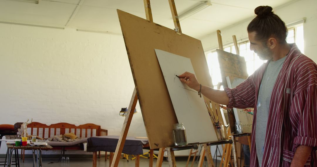 Artist Drawing on Easel in Spacious Studio with Natural Light - Free Images, Stock Photos and Pictures on Pikwizard.com