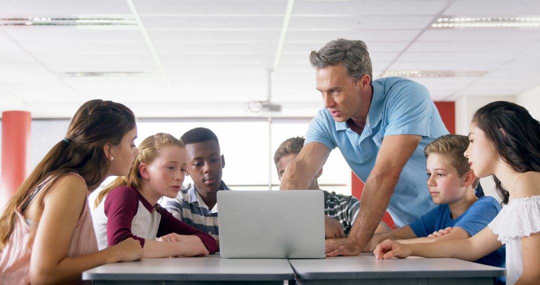 Teacher Engaging Group of Students Around Laptop in Classroom - Free Images, Stock Photos and Pictures on Pikwizard.com