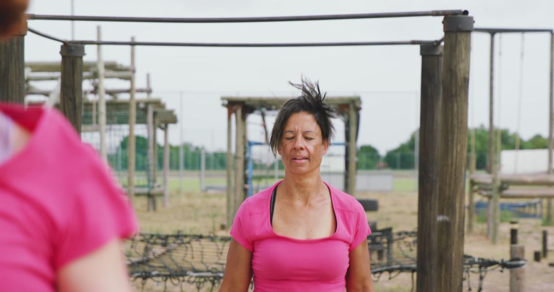 Woman training outdoors on obstacle course wearing pink t-shirt - Free Images, Stock Photos and Pictures on Pikwizard.com