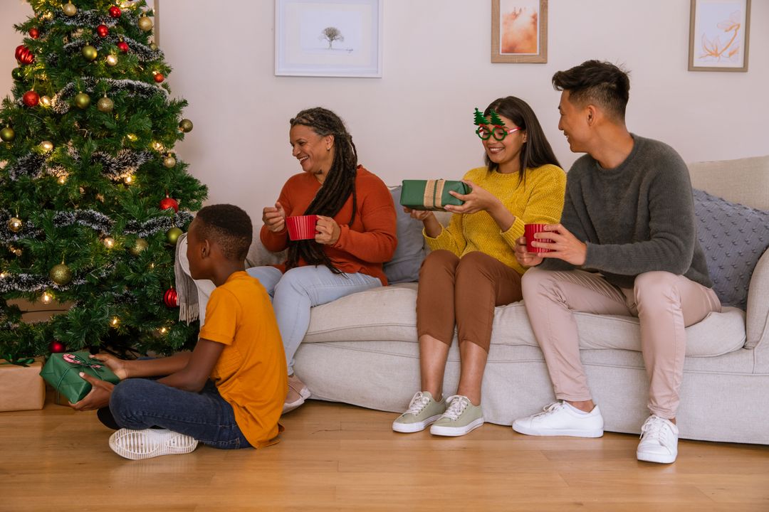 Diverse Family Gathering Exchanging Gifts by Christmas Tree