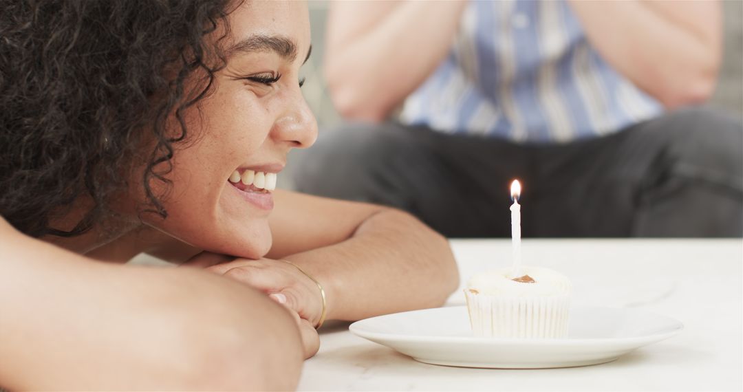 Happy Woman About to Blow Candle on Birthday Cupcake