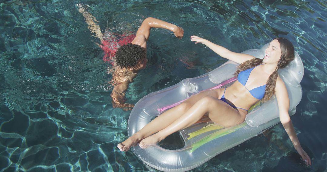 Couple Enjoying Summer Fun in Outdoor Pool with Inflatable - Free Images, Stock Photos and Pictures on Pikwizard.com