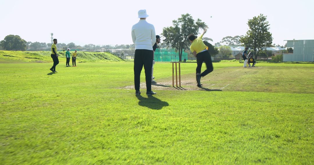 Cricket Players Competing on Sunny Field