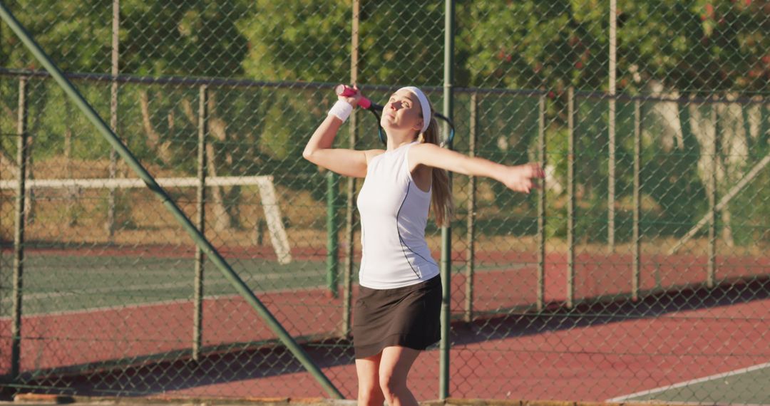 Female tennis player serving on outdoor court during sunny day - Free Images, Stock Photos and Pictures on Pikwizard.com