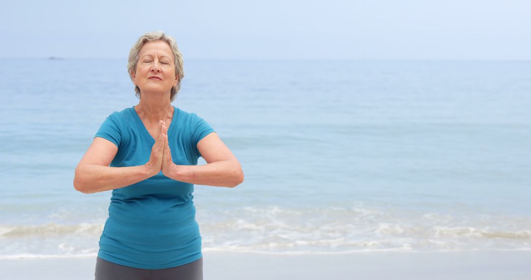 Senior Woman Meditating by Ocean, Peaceful and Calm Surroundings - Free Images, Stock Photos and Pictures on Pikwizard.com