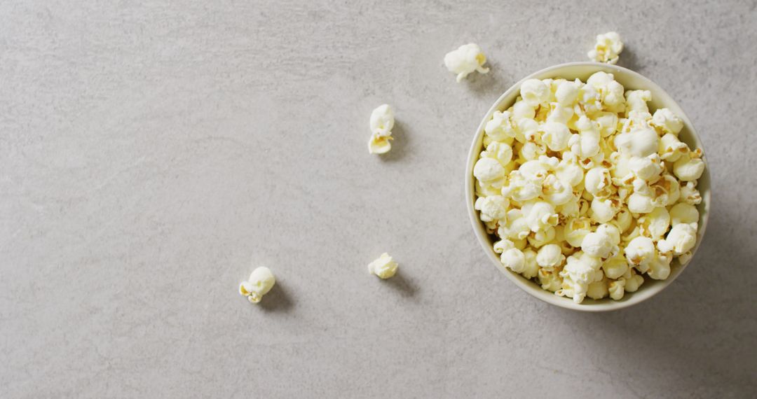 Bowl of Popcorn on Gray Background with Scattered Kernels - Free Images, Stock Photos and Pictures on Pikwizard.com