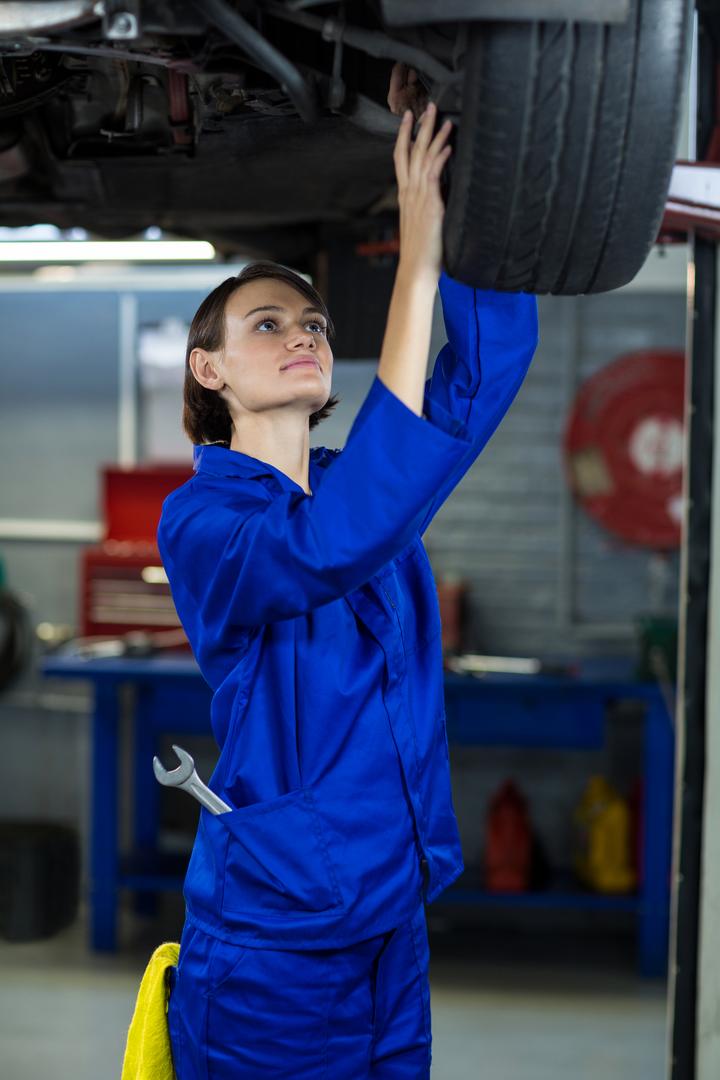 Female Mechanic Inspecting Car Wheel in Auto Repair Shop - Free Images, Stock Photos and Pictures on Pikwizard.com