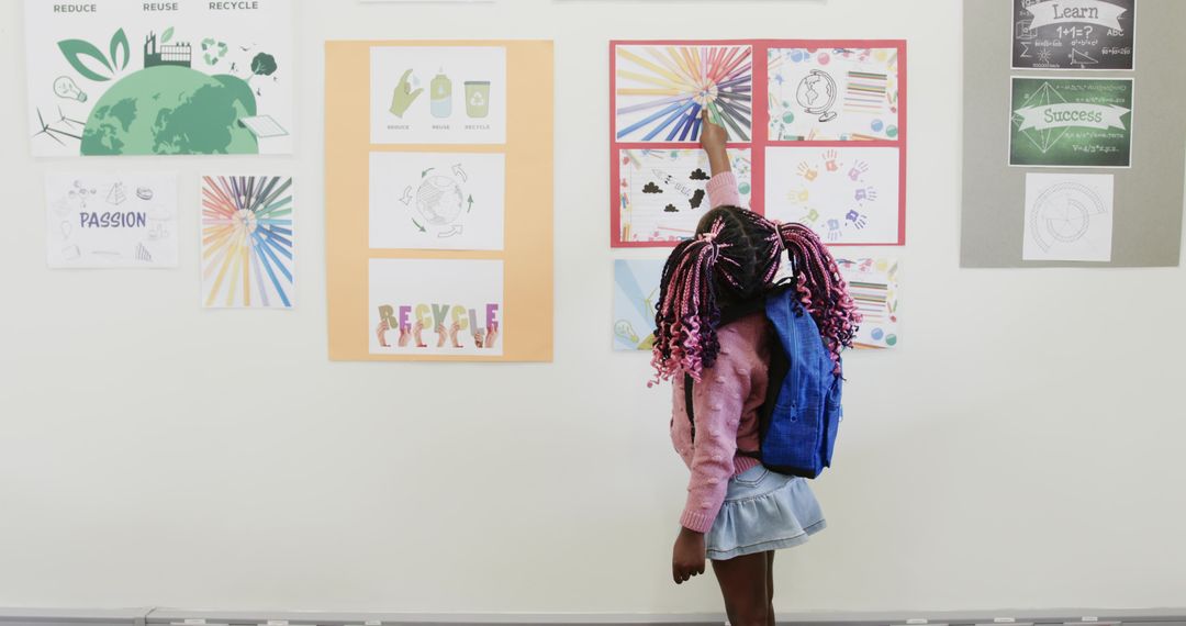 Curious Child with Backpack Pointing at Bright Classroom Posters