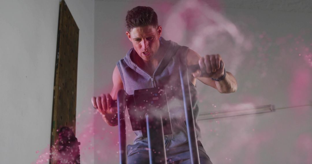 Man Exercising on Elliptical with Pink Powder Swirl in Gym