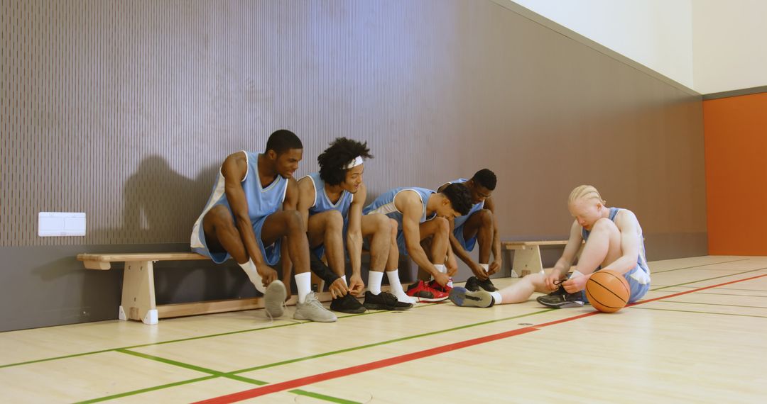 Diverse Basketball Team Preparing for Game on Court Bench