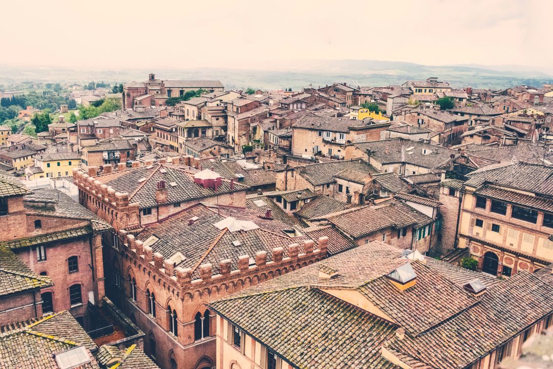 Aerial panoramic view of terracotta rooftops in Tuscan hill town with medieval architecture