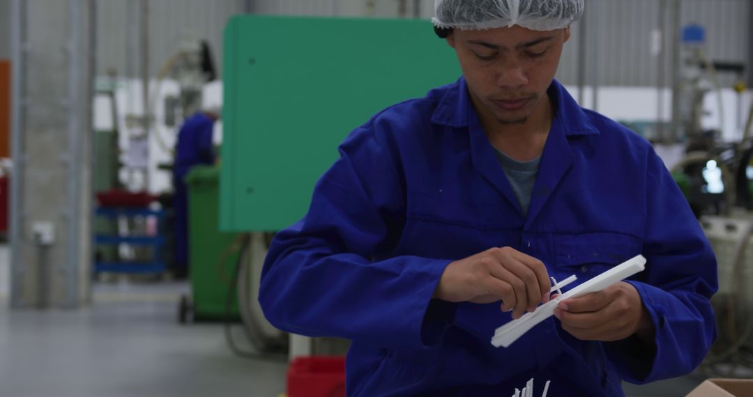 Industrial Worker Inspecting Plastic Parts in Manufacturing Facility - Free Images, Stock Photos and Pictures on Pikwizard.com