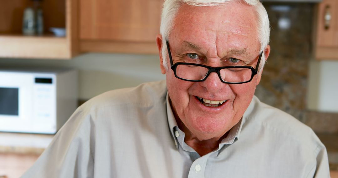 Smiling Senior Man Wearing Glasses Enjoying Kitchen Setting - Free Images, Stock Photos and Pictures on Pikwizard.com