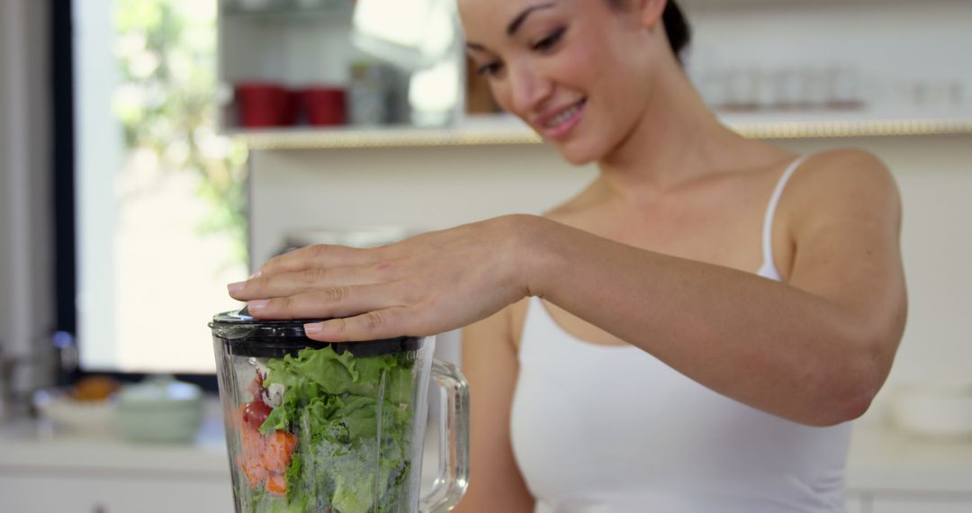 Smiling Woman Blending Fresh Vegetables for Healthy Smoothie in Kitchen - Free Images, Stock Photos and Pictures on Pikwizard.com