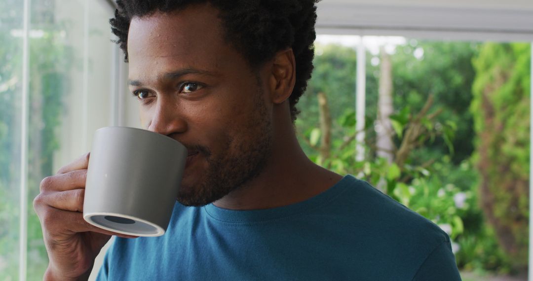 Calm Young Man Drinking Coffee at Home with a Smile