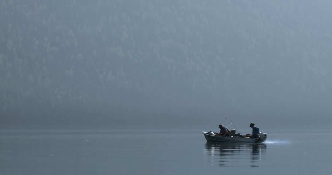 Two Men Fishing on Calm Lake Surrounded by Misty Forest - Free Images, Stock Photos and Pictures on Pikwizard.com