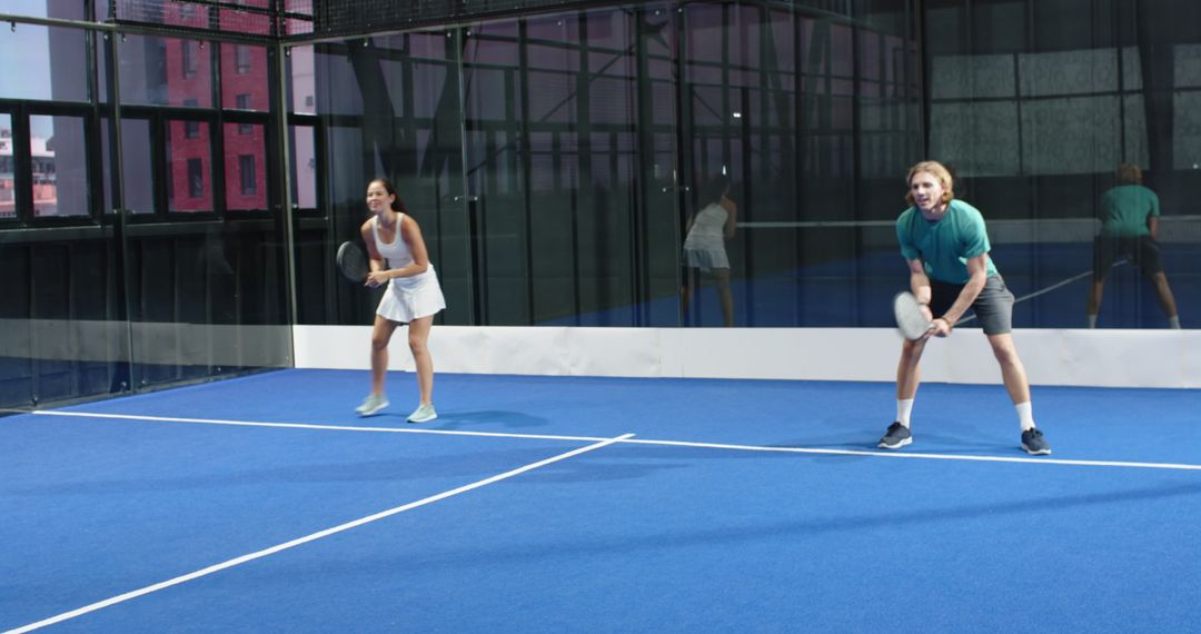 Coed Players on Padel Court Show Enthusiastic Competitiveness