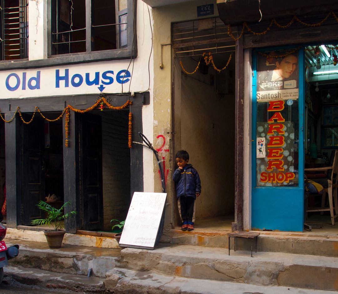 Child Standing in Doorway of Traditional Building in Urban Setting - Free Images, Stock Photos and Pictures on Pikwizard.com