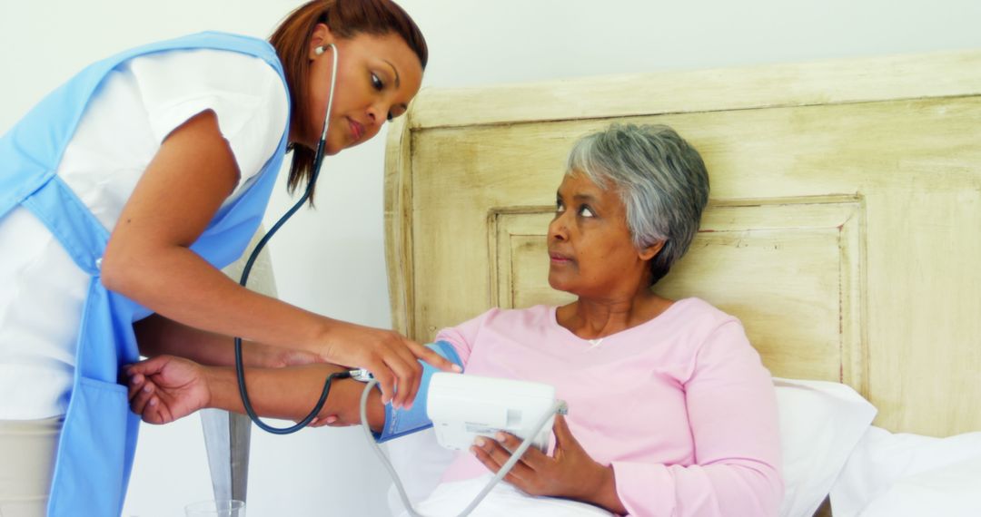 Nurse Checking Blood Pressure of Elderly Woman in Bed - Free Images, Stock Photos and Pictures on Pikwizard.com