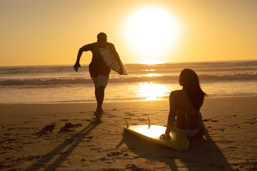 Couple Enjoying Sunset Surfing on Beach - Free Images, Stock Photos and Pictures on Pikwizard.com
