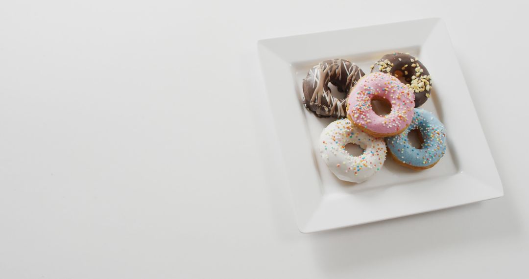 Image of donuts with icing on white plate over white background - Free Images, Stock Photos and Pictures on Pikwizard.com