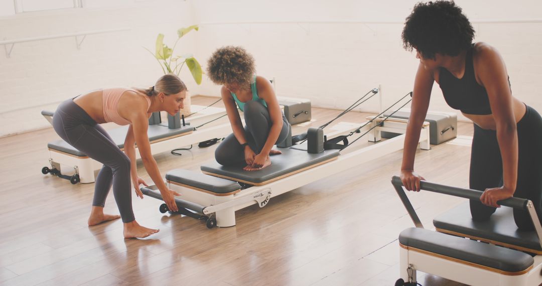 Diverse Group of Women Performing Pilates in Modern Studio