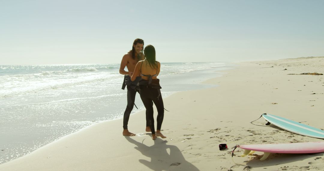 Couple Preparing to Surf on Sunny Beach, Standing Next to Surfboards - Free Images, Stock Photos and Pictures on Pikwizard.com