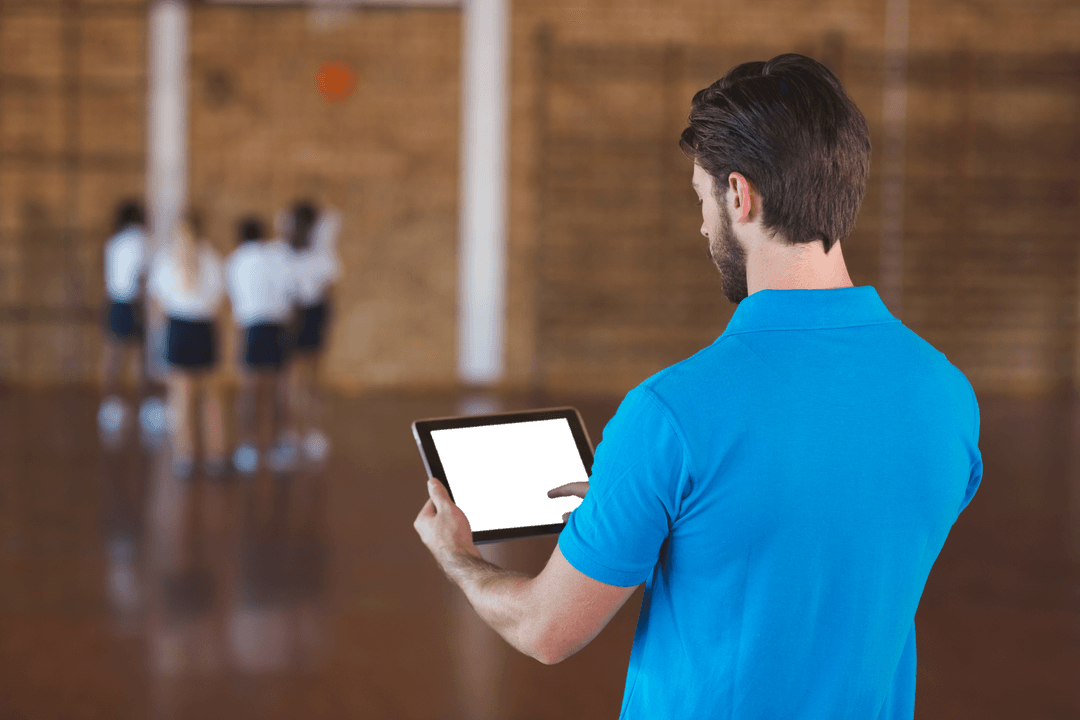 Coach Strategizing with Tablet in Transparent Gym Setting