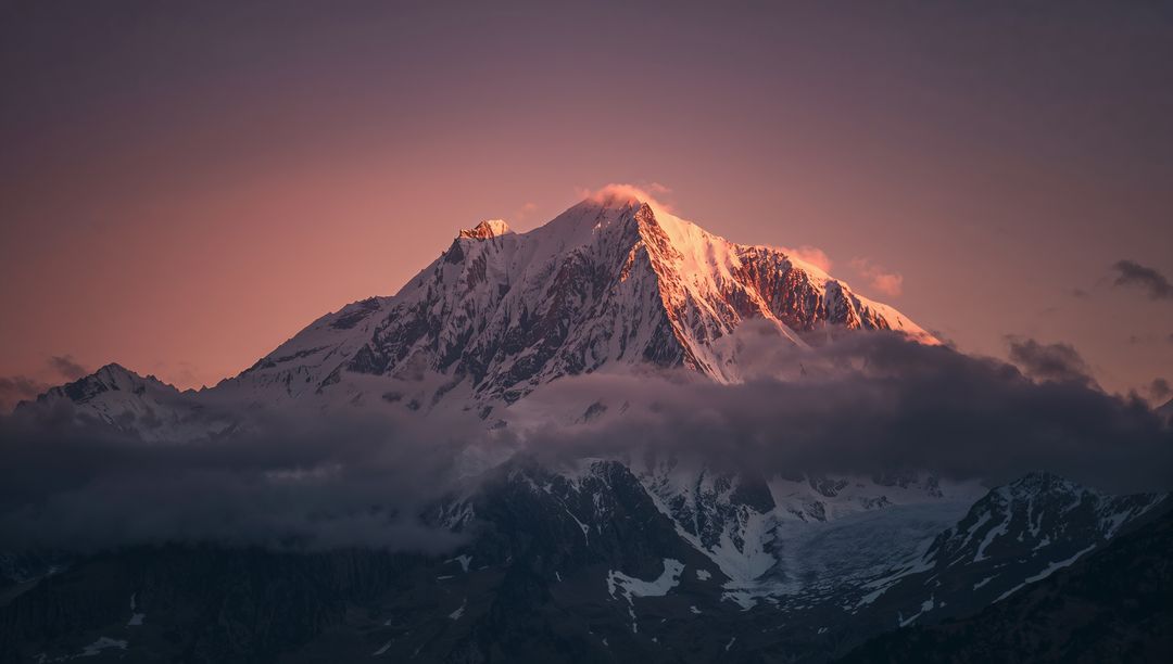 Majestic Snow-Capped Peak at Dawn with Pink-Orange Glow