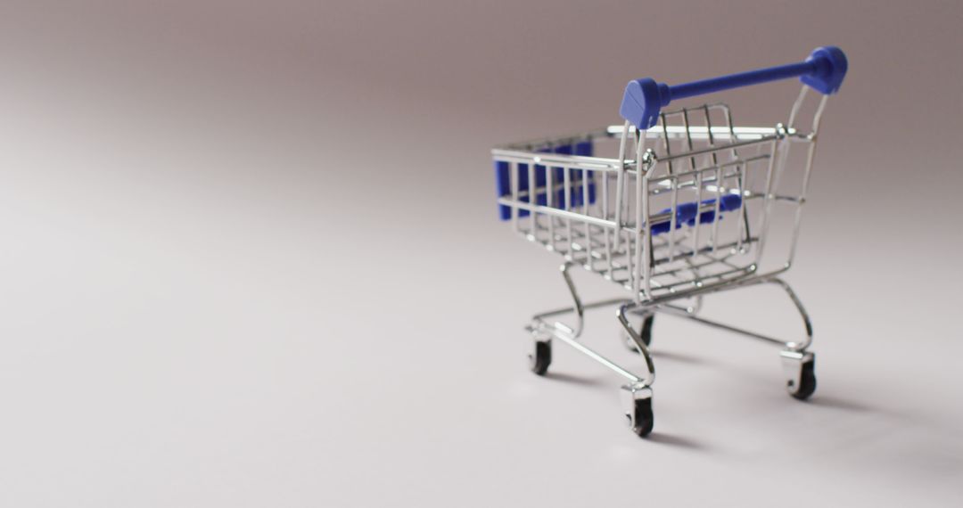 Empty blue shopping trolley on seamless grey background - Free Images, Stock Photos and Pictures on Pikwizard.com