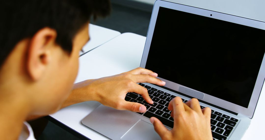 Teenage Boy Typing on Laptop in Classroom Setting - Free Images, Stock Photos and Pictures on Pikwizard.com