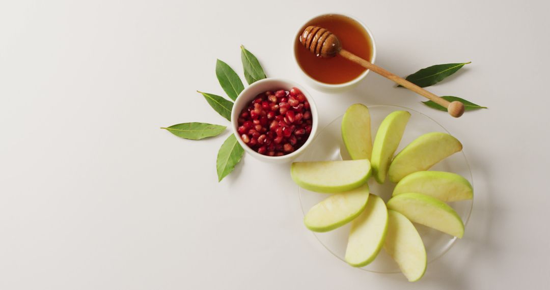 Fresh Honey, Pomegranate Seeds, and Sliced Apples on Table