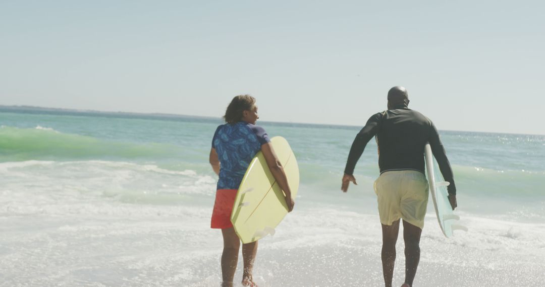 Two Friends Going to Surf at Beach with Surfboards on Sunny Day - Free Images, Stock Photos and Pictures on Pikwizard.com